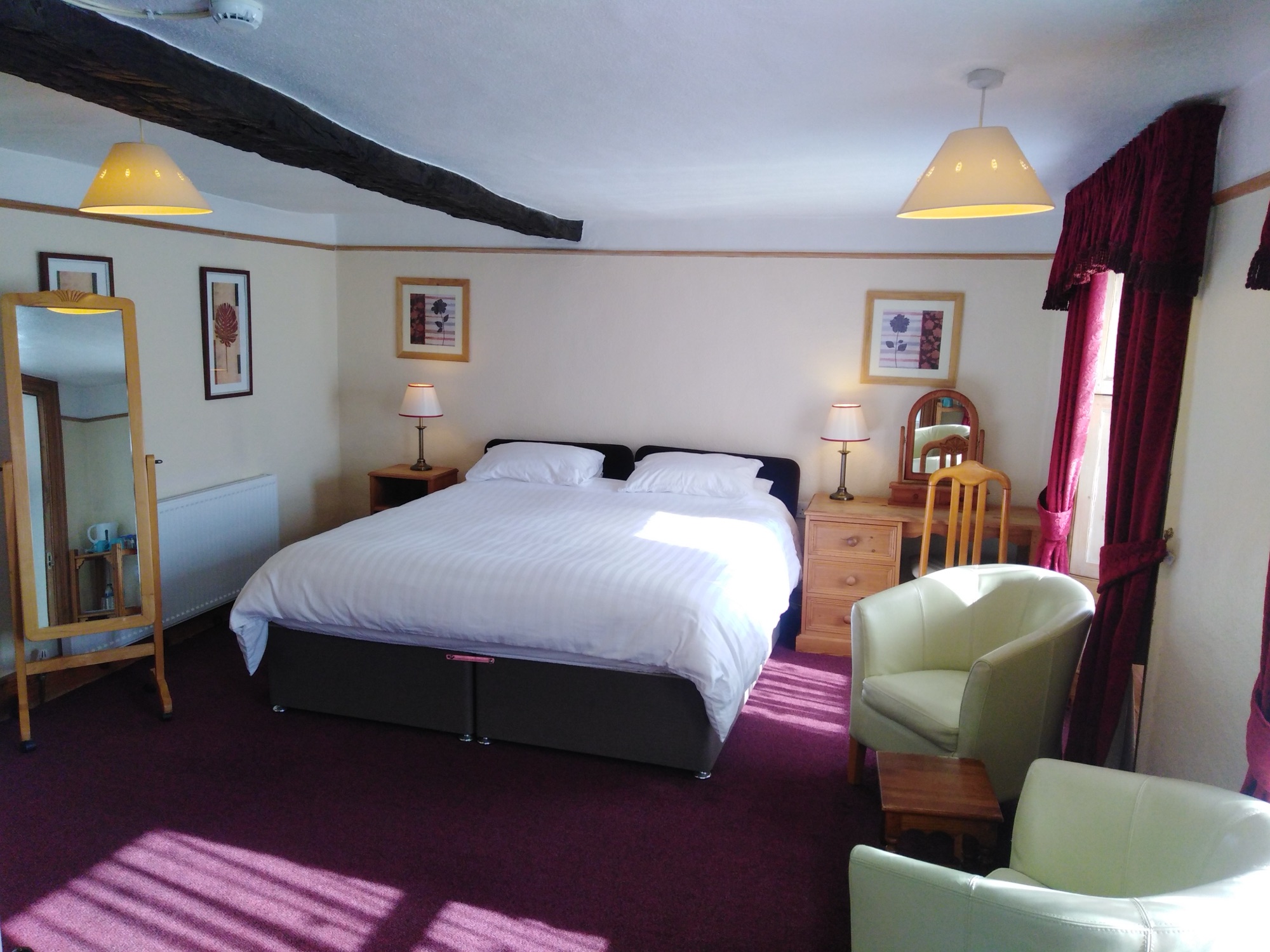 Room 4: a superking bed under the old beams, with armchairs by the window